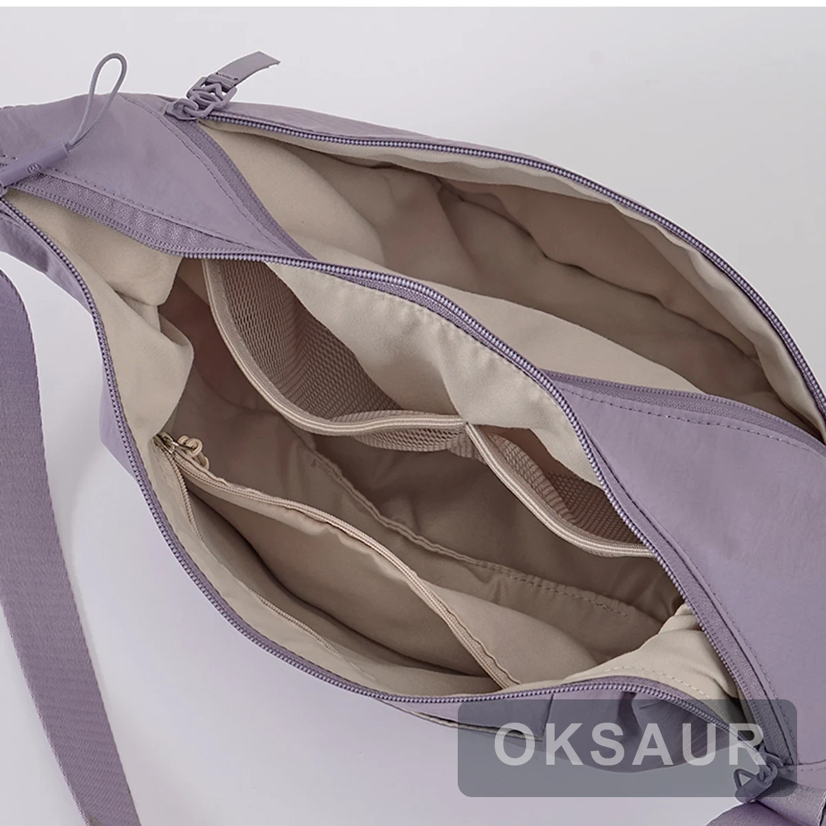 Open purple crescent crossbody bag showing its main compartment and internal organizer pockets