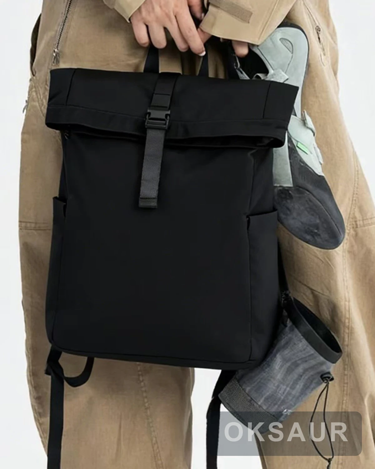 Black roll-top backpack shown with its structured front panel